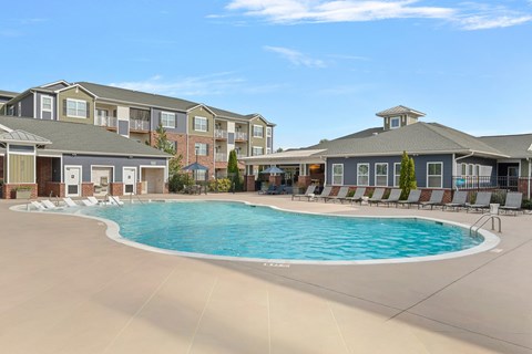 A large swimming pool in front of apartment buildings.