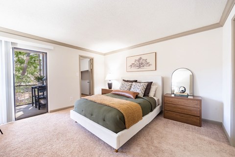 A bedroom with a large bed and a sliding glass door.