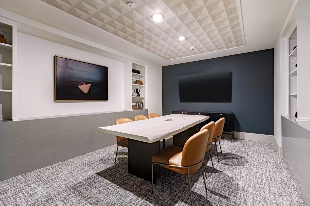 A conference room with a white table and chairs.