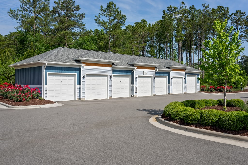 A row of garage doors are closed and the building is blue and white.