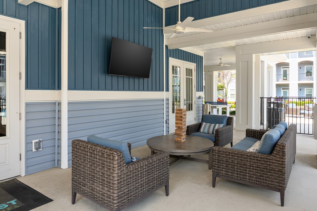 A patio with a table and chairs and a television on the wall.