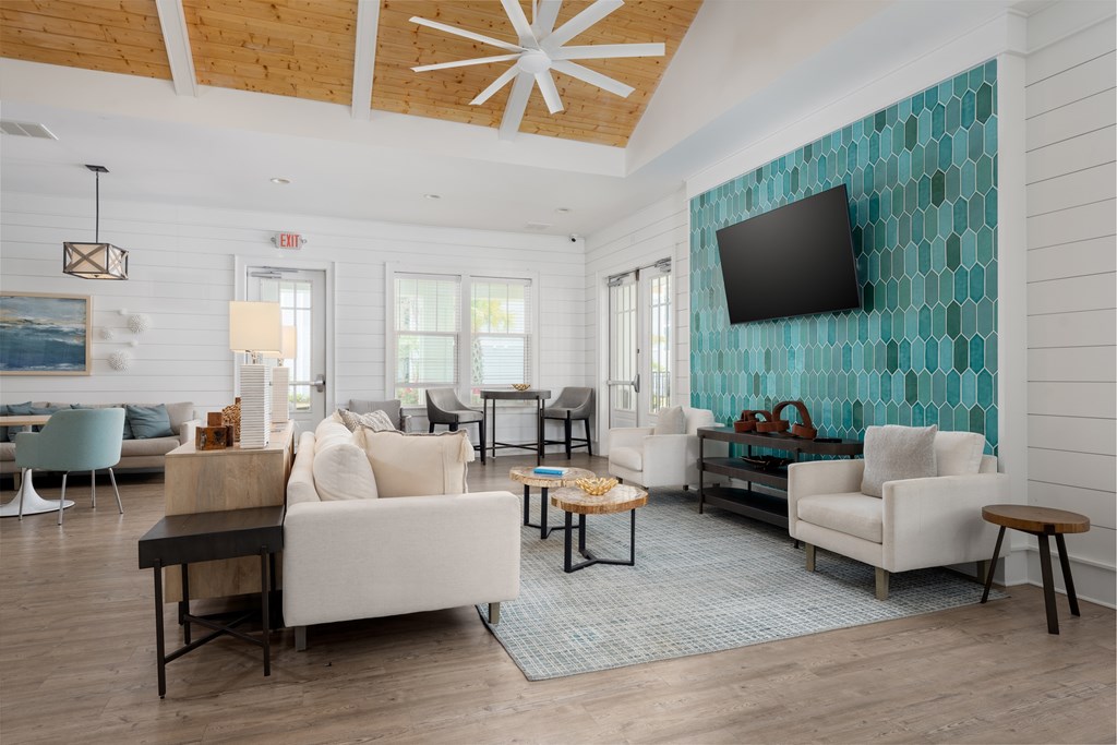 A living room with a white couch and a blue wallpaper.