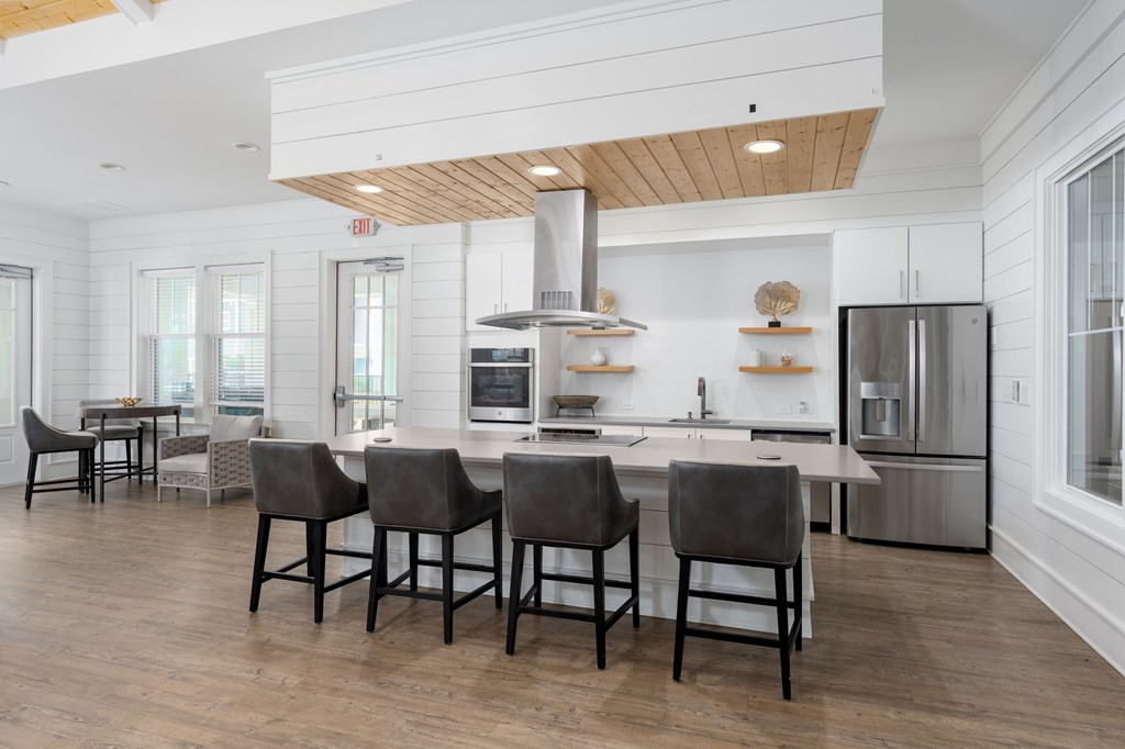 A kitchen with a white color scheme and wooden beams on the ceiling.