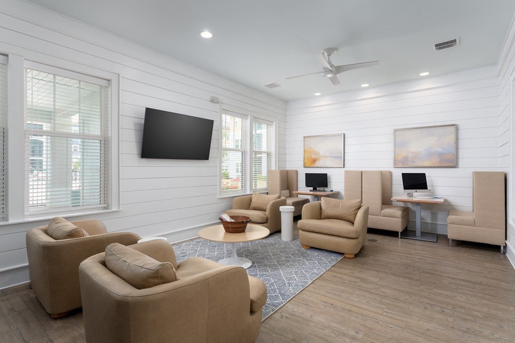 A living room with a television, chairs, and a table.