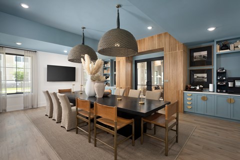 A modern dining room with a black table and chairs.