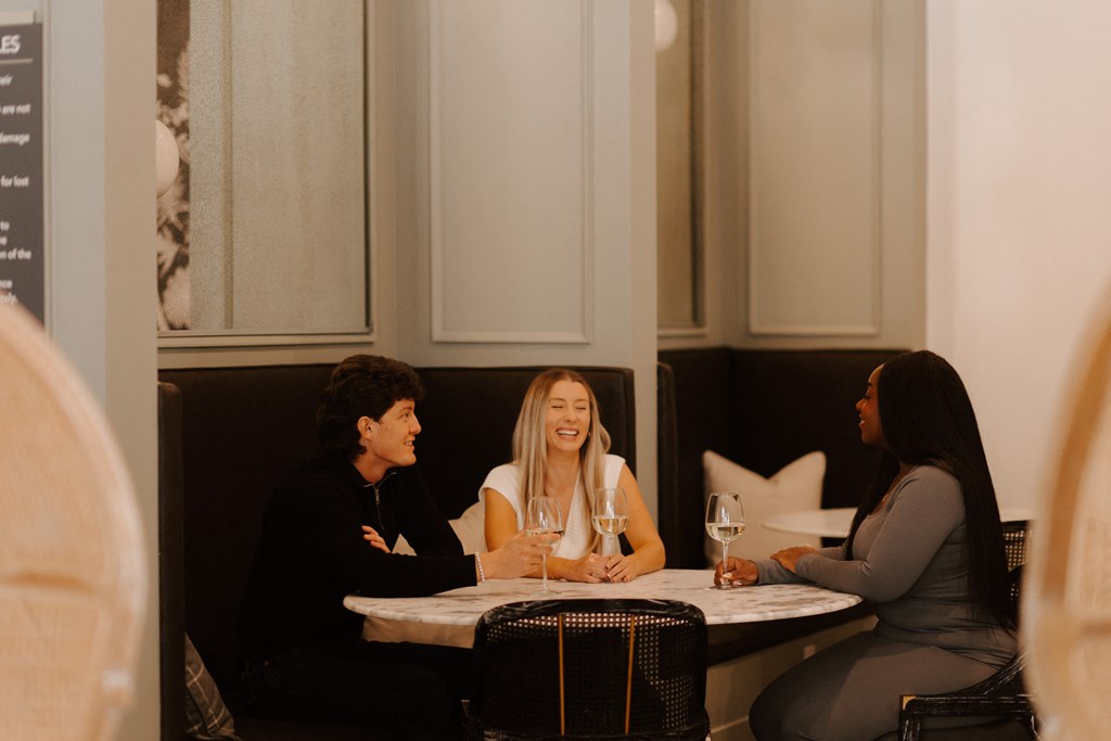 Three people are sitting at a table in a restaurant.