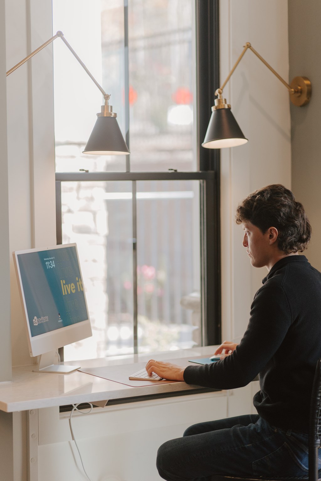 A man is sitting at a desk with a computer, working.