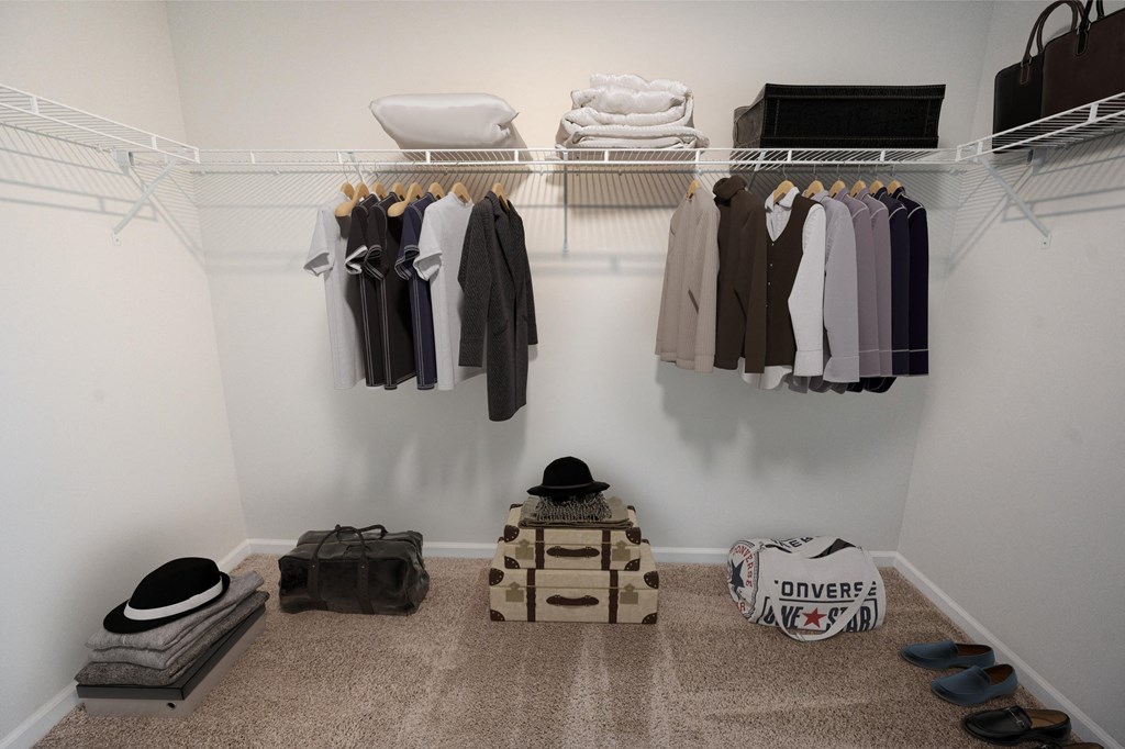 a walk in closet with a rack of clothes and shoes