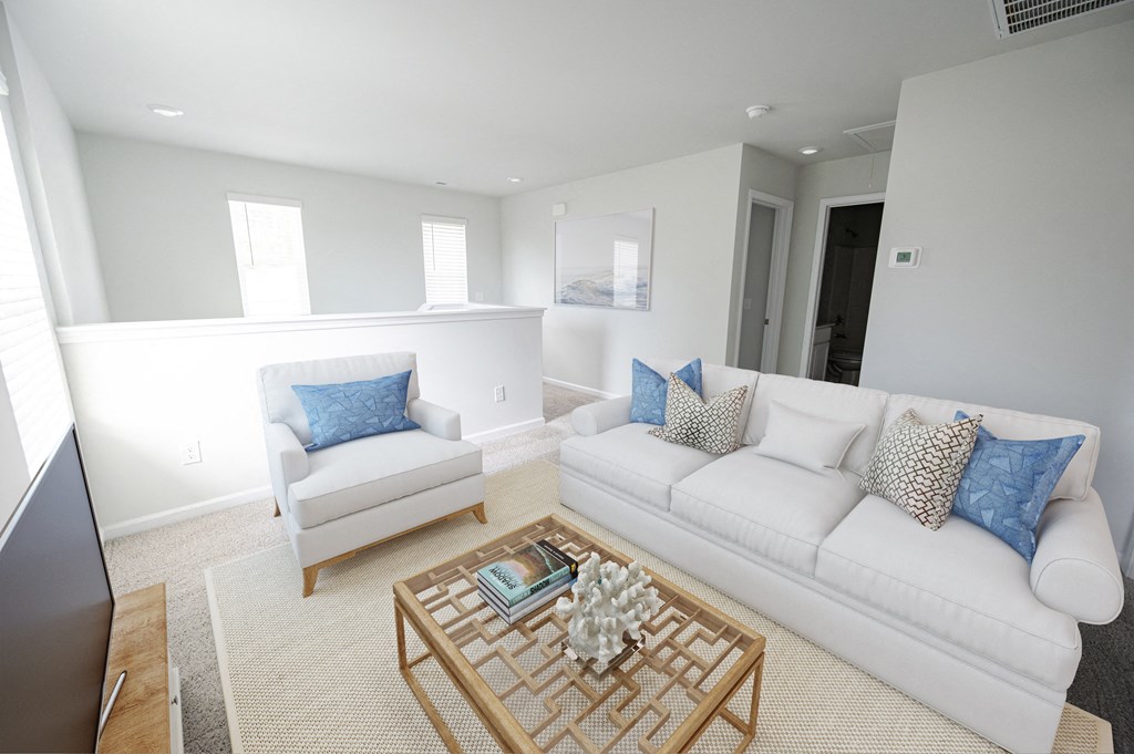 a living room with white couches and a coffee table