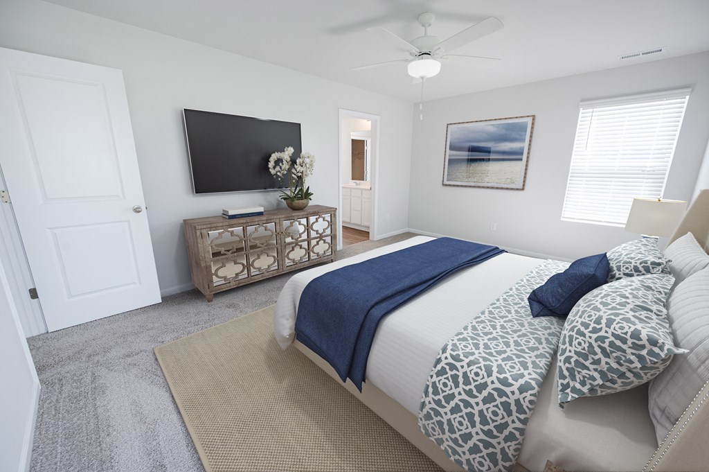a bedroom with a large bed and a tv on the wall