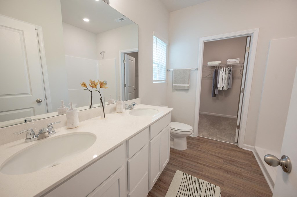 a bathroom with two sinks and a toilet and a shower