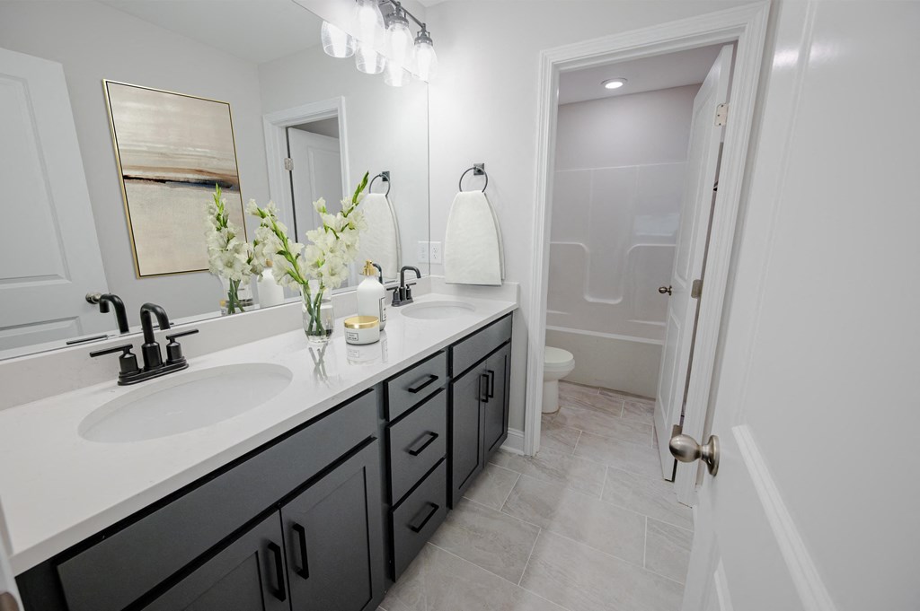 a black and white bathroom with two sinks and a shower