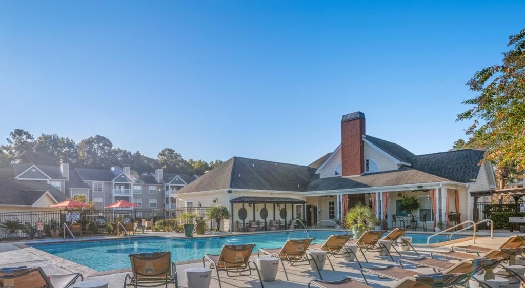 A large clubhouse with a pool in front at Palmetto Pointe apartments in Myrtle Beach, SC.