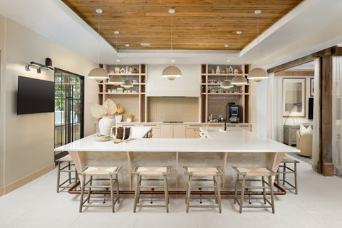 A modern dining room with a wooden ceiling and a long table with chairs.