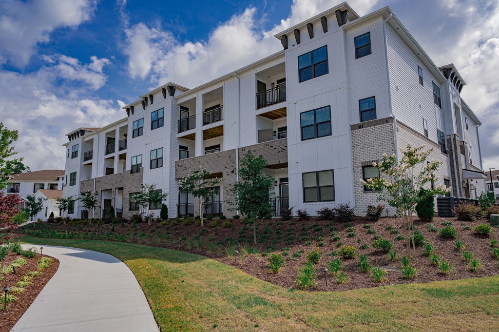 A white apartment building with a walkway in front.