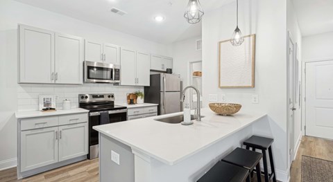 A kitchen with white cabinets and a white island.