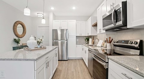 A kitchen with white cabinets and stainless steel appliances.