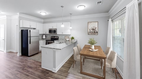 A kitchen with a table and chairs in the middle of the room.