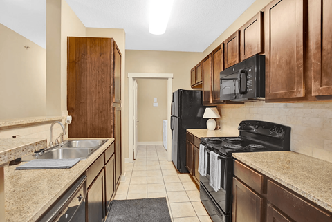 A kitchen with black appliances and wooden cabinets.