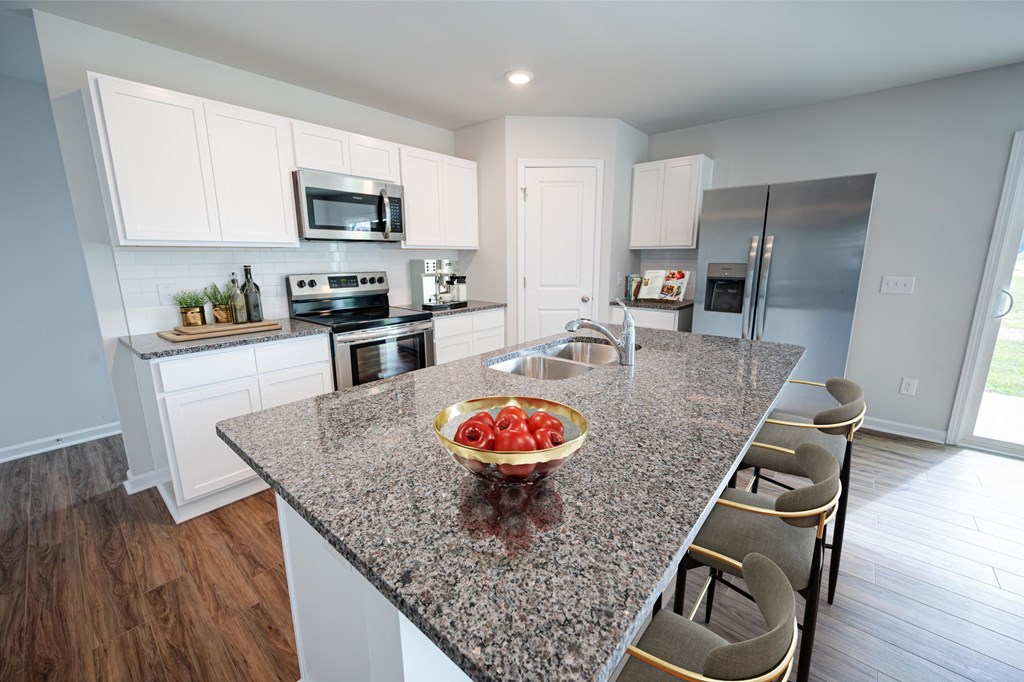 a kitchen with a granite counter top island with a bowl of fruit