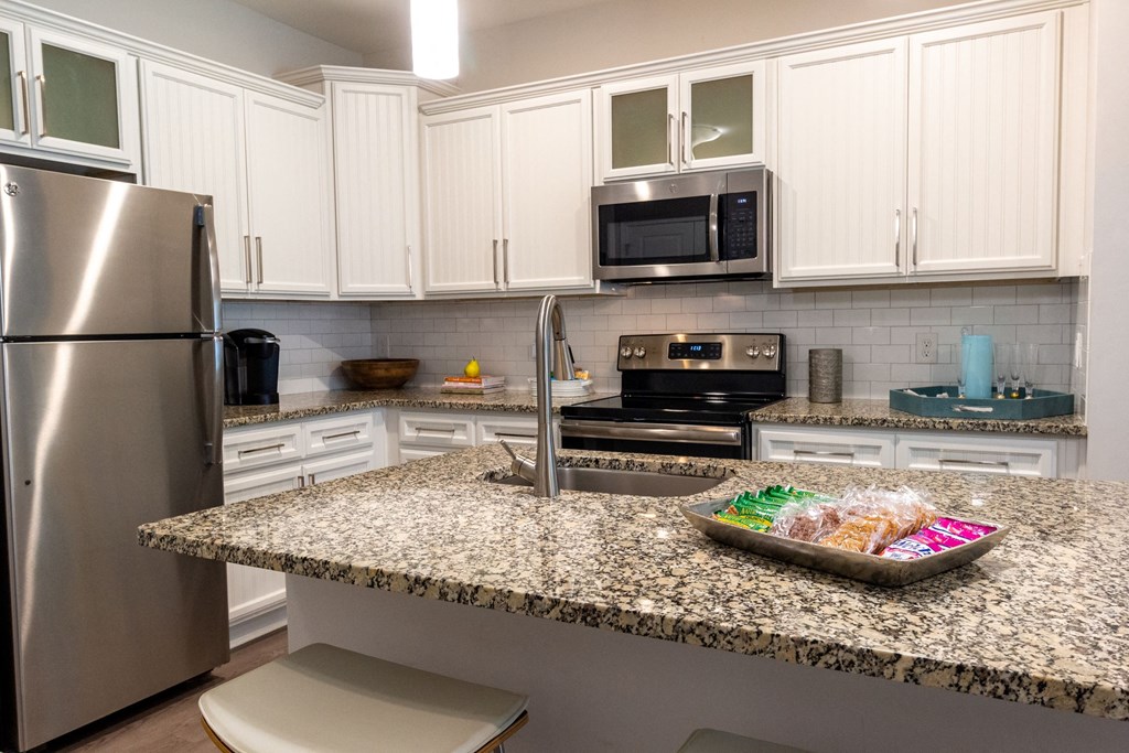 a kitchen with granite counter tops and stainless steel appliances