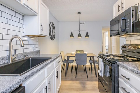 a kitchen with a sink and a table with chairs