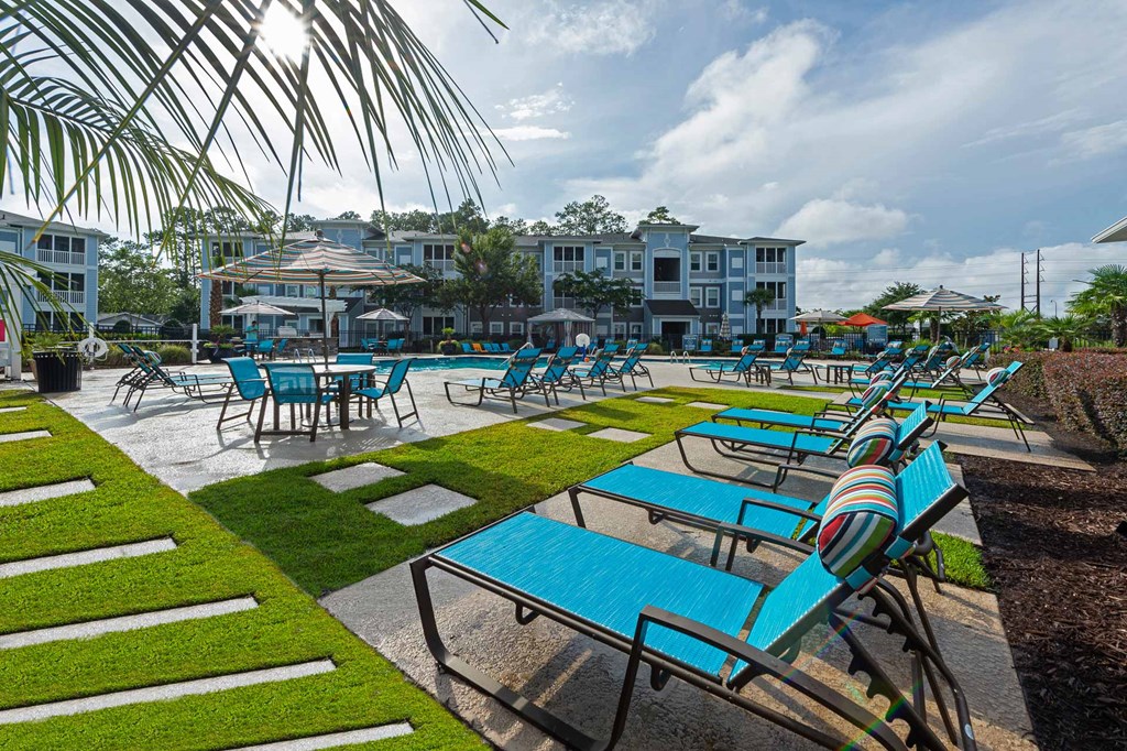 a group of blue tables and chairs near a pool