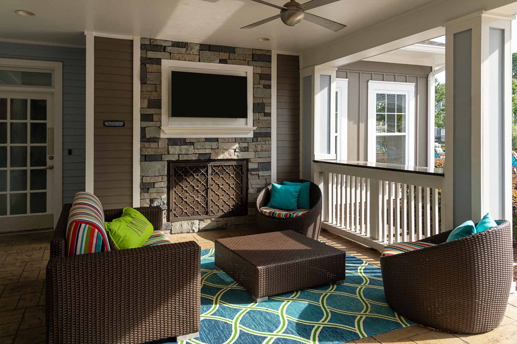 a screened porch with a fireplace and a tv
