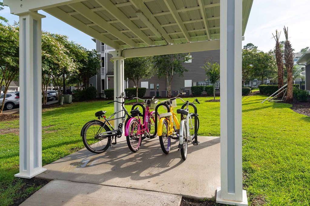 four bicycles are parked under a pavilion