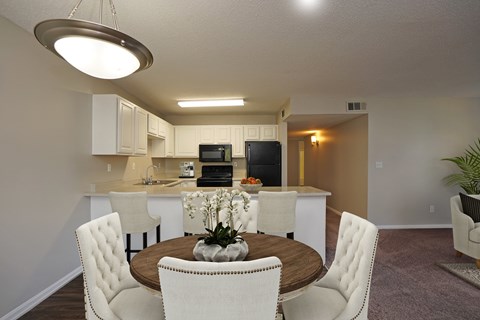 A modern kitchen with a dining table and chairs.