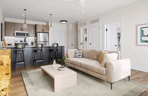 A modern living room with a beige sofa and a coffee table.