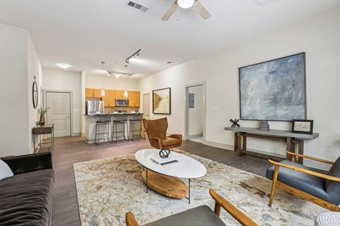 A living room with a brown couch, a coffee table, and a painting on the wall.