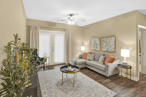 A living room with a couch, a coffee table, and a ceiling fan.