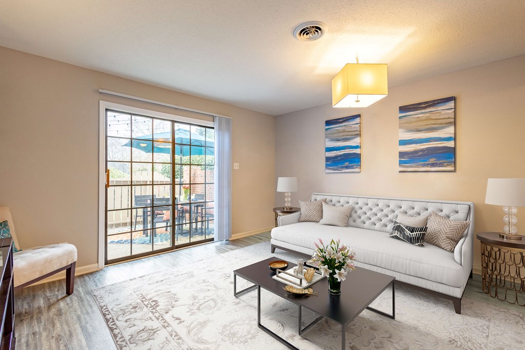 a living room with a white couch and a sliding glass door
