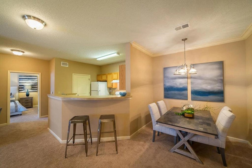 a dining room and kitchen with a table and chairs