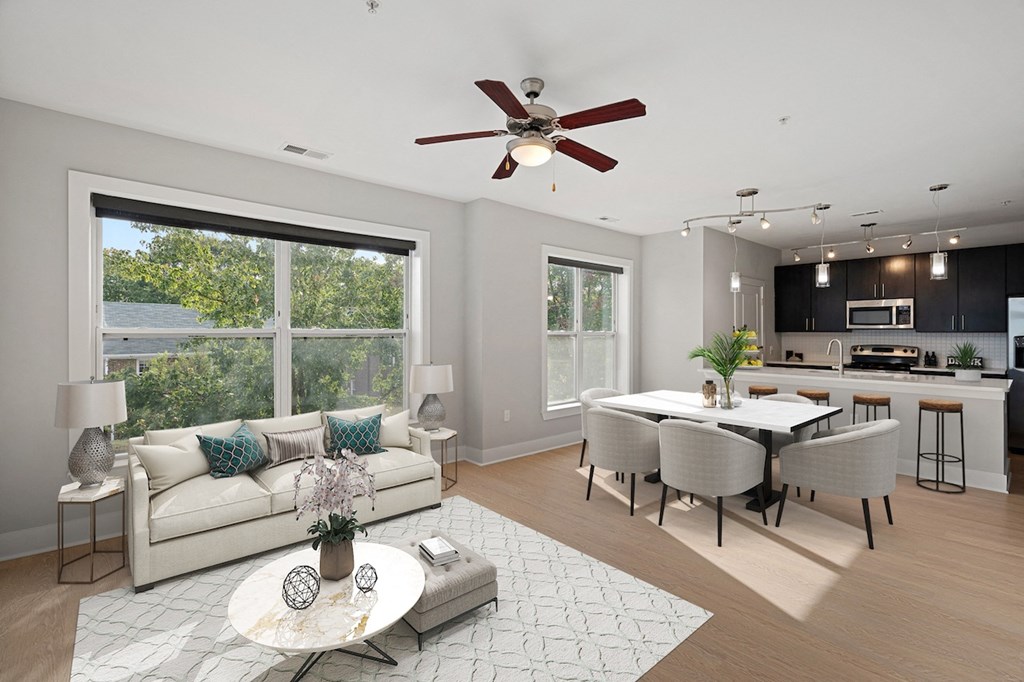 a living room and dining room with a large window and a ceiling fan