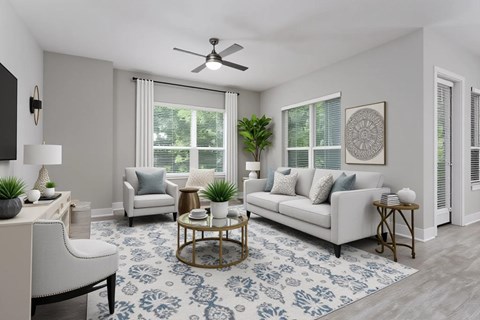 A living room with a white couch, a coffee table, and a ceiling fan.