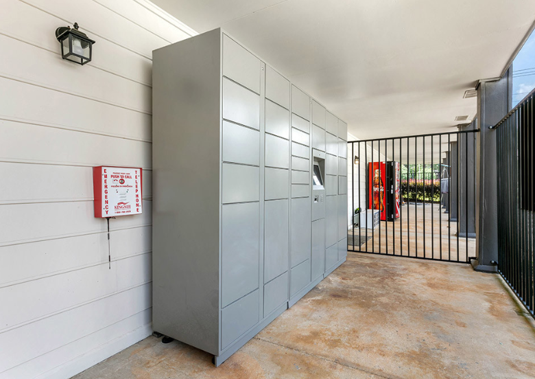 a passage with a metal gate and lockers on the wall
