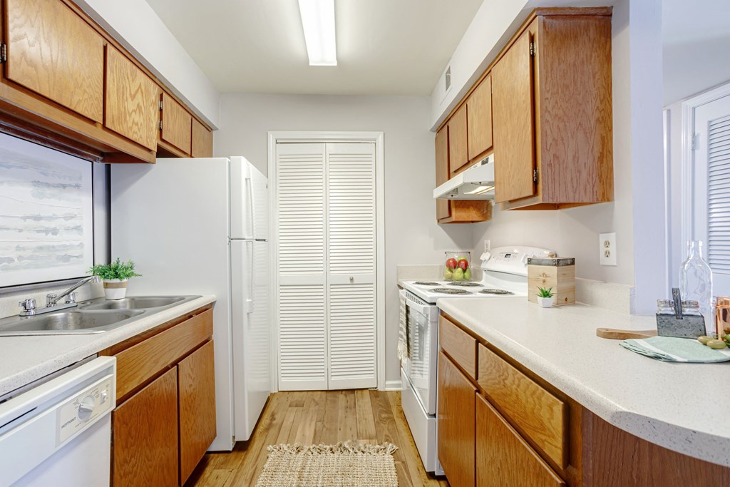 kitchen with white appliances and white countertops with light cabinetry