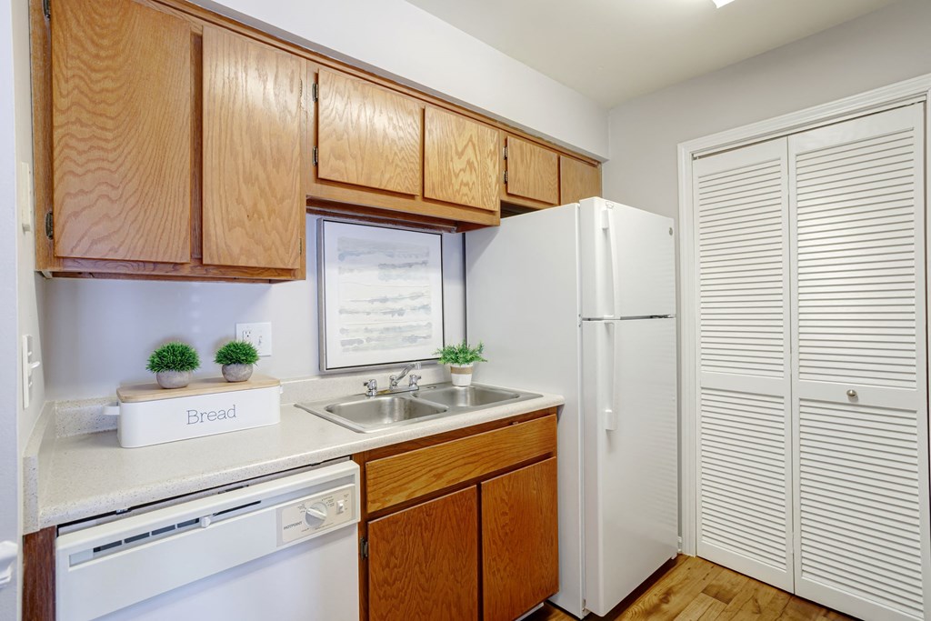 kitchen with white appliances and white countertops with light cabinetry