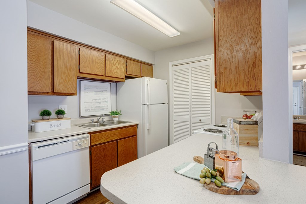 kitchen with white appliances and white countertops with light cabinetry