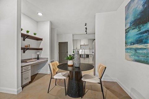 A modern kitchen with a dining table set for two.
