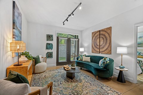 A living room with a green couch and a rug.