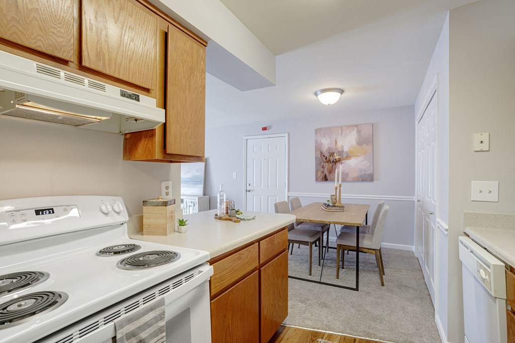kitchen with white appliances and white countertops with light cabinetry