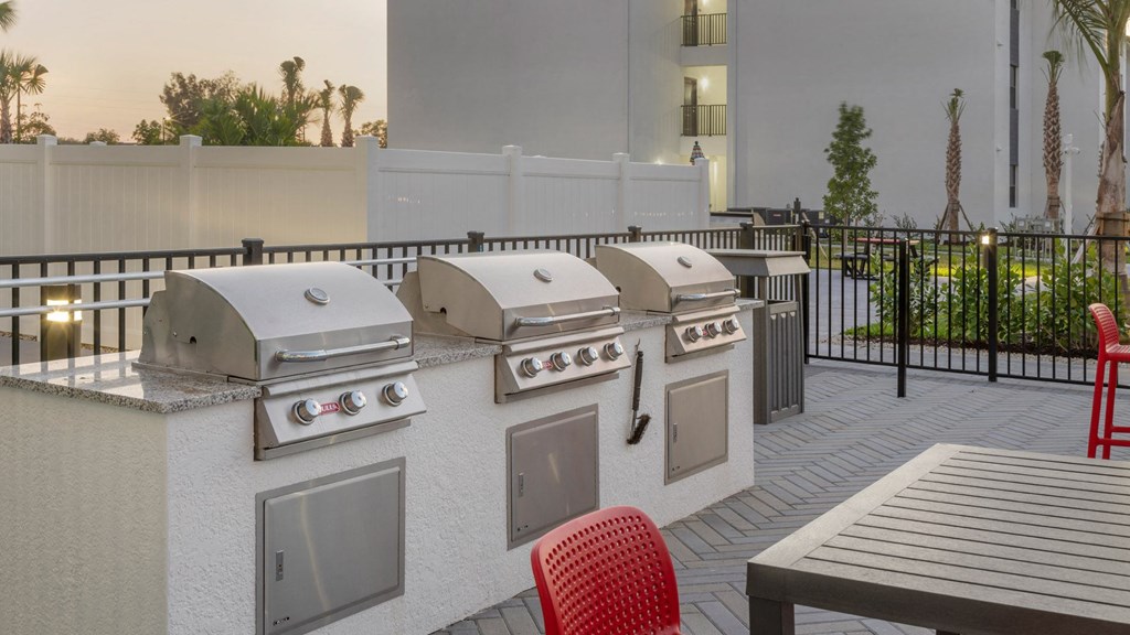 a barbecue grill in a patio with four bbqs and tables