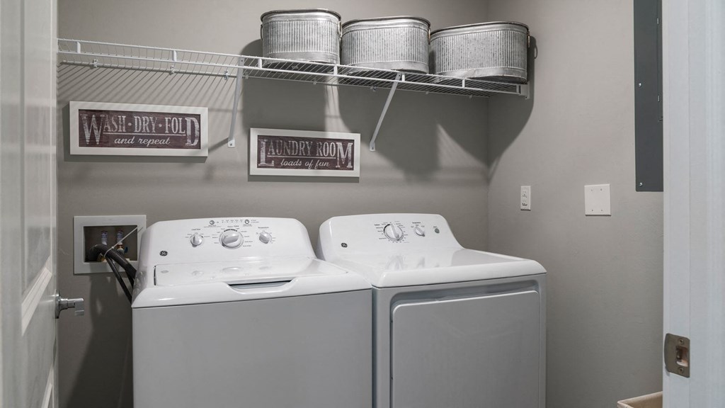 a washer and dryer in a laundry room with pots and pans hanging above