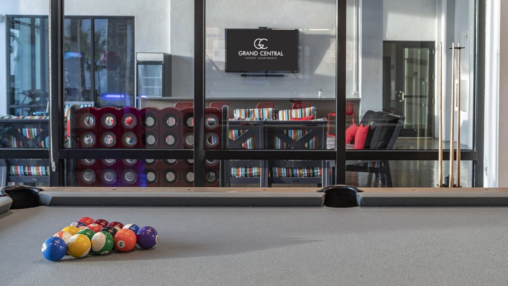 a gym with a row of balls on the floor in front of a window