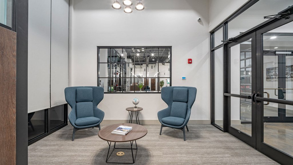 a lobby with two blue chairs and a coffee table