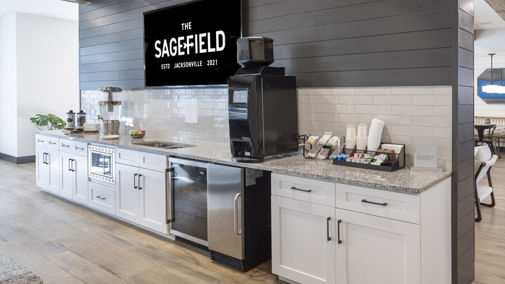 a kitchen with white cabinets and a counter top with a sink and a coffee maker