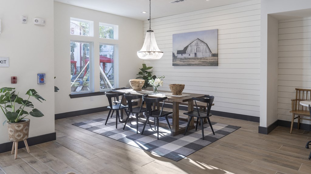 a dining room with a wooden table and chairs and a painting on the wall